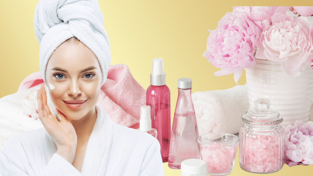 Radiant woman in a white robe and towel on her head gently applying cream to her cheek, surrounded by an assortment of pink-themed skincare products, towels, and fresh pink peonies against a soft yellow backdrop.